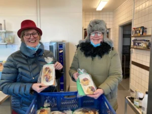 To damer i overtøj med fastelavnsboller